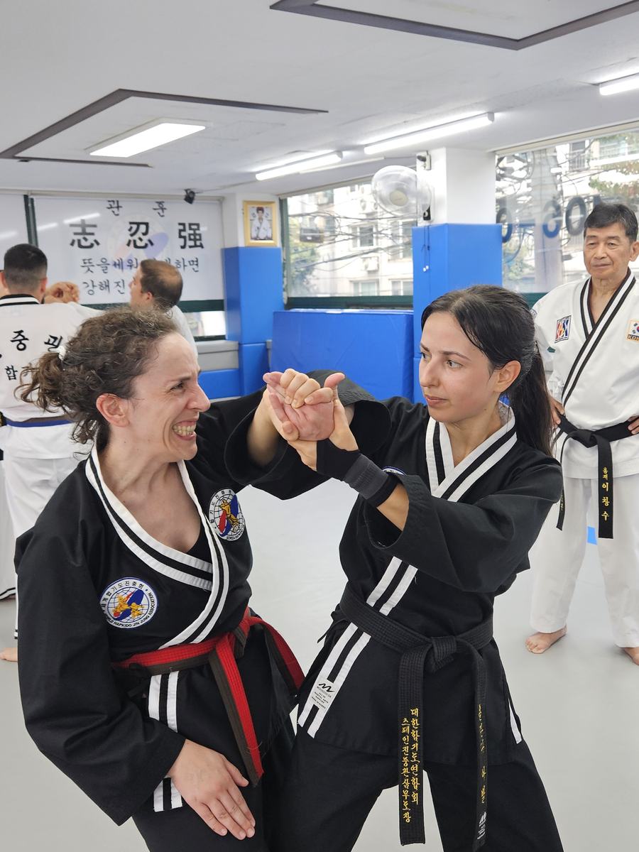 Dos alumnas practicando defensa personal en el tatami